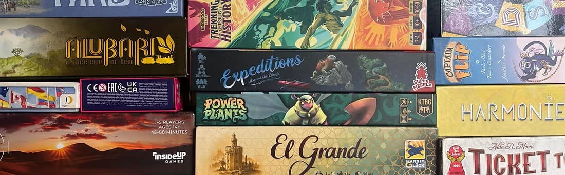 Stacked board games with colorful and diverse box art