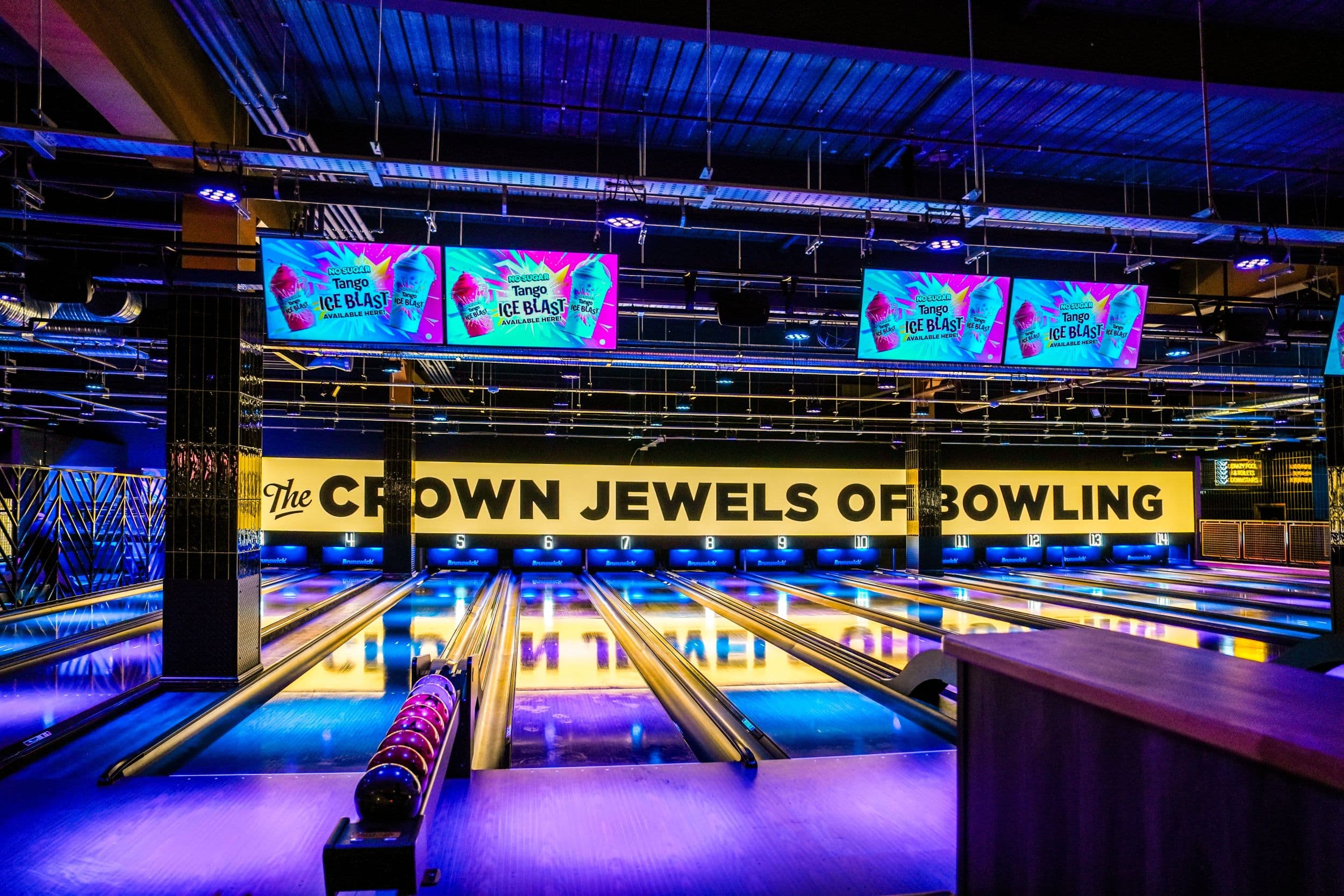 Modern bowling alley with neon lights and colorful screens